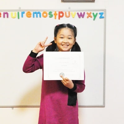 Otisの英会話教室の生徒ちゃんが２０２２年度の英検ジュニアの受験証明書を手に持って、撮影した写真