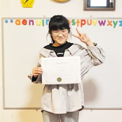 Otisの英会話教室の生徒ちゃんが２０２２年度の英検ジュニアの受験証明書を手に持って、撮影した写真